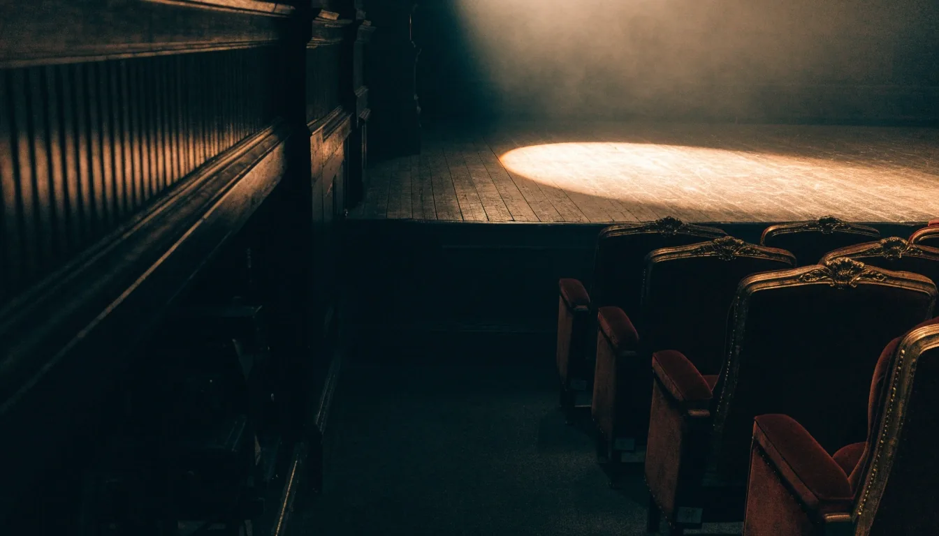 Ein leerer Theatersaal kurz vor der Abendvorstellung, ein Lichtkegel auf der Bühne